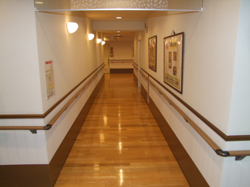 回廊式の廊下は幅もゆったり。木のフローリングと白い壁が清潔感と温かみを両立
